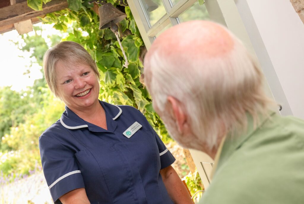 A Shipston Home Nursing nurse warmly greeting an elderly patient at home
